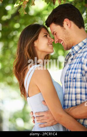 Tief verliebt. Kurze Aussicht auf ein glückliches junges Paar, das im Park zusammen steht. Stockfoto