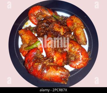 Gebratener Fisch mit Gemüse. Gebratene Fischflügel. Gebratener Fisch auf einem Teller Stockfoto