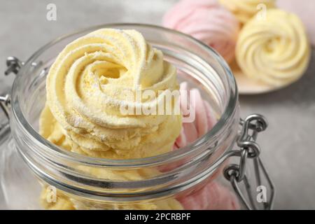 Gelb und rosa köstliche Marshmallows in Glasgefäß auf dem Tisch, Nahaufnahme Stockfoto