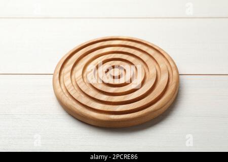 Stilvolle Untersetzer mit Holztasse auf weißem Tisch Stockfoto
