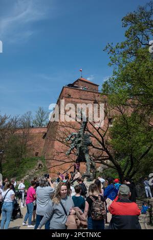 Touristen an der Wawel-Drachenstatue ( Smoka Wawelskiego), einem Denkmal am Fuße des Wawel-Hügels, das dem mythischen Wawel-Drachen in Krakau gewidmet ist Stockfoto