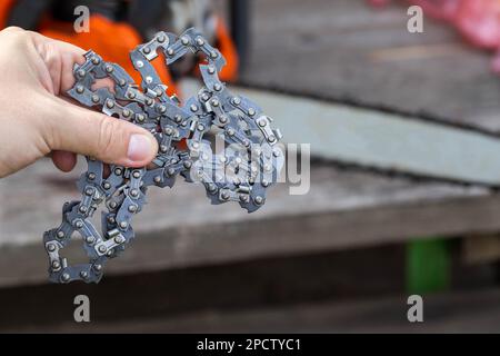Neue Kette für Motorsäge. Aufbau und Austausch der Kette an der Motorsäge von der alten zur neuen. Schärfen der Kette. Stockfoto