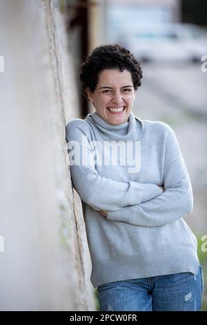 Schöne glückliche Frau, die draußen lacht Stockfoto