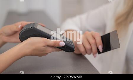 Frau, die per Kreditkarte per NFC kontaktlos bezahlt. Stockfoto