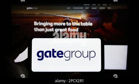 Person, die ein Smartphone mit dem Logo der Schweizer Gategroup Holding AG auf dem Bildschirm vor der Website hält. Konzentrieren Sie sich auf das Display des Telefons. Stockfoto