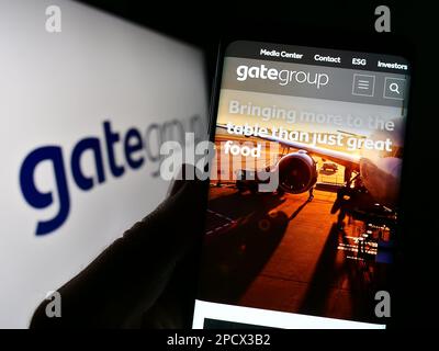 Person, die ein Handy hält, mit Webseite der Schweizer Gategroup Holding AG auf dem Bildschirm vor dem Logo. Konzentrieren Sie sich auf die Mitte des Telefondisplays. Stockfoto