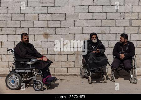 Mashhad Ruhin, Syrien. 14. März 2023. Kriegsbehinderte syrische Flüchtlinge sitzen im Rollstuhl im Lager Mashhad Ruhin. Das Lager Mashhad Ruhin, das früher als "Witwenlager" bekannt war, beherbergt Hunderte syrischer Flüchtlinge im Nordwesten Syriens, von denen die meisten Witwen, alleinstehende Frauen mit Kindern und Menschen mit Behinderungen sind. Kredit: Anas Alkharboutli/dpa/Alamy Live News Stockfoto