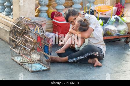 Phnom Penh, Kambodscha-Dezember 23 2023: Eine Khmer-Frau, die kleine Vögel im Käfig an Khmer verkauft, um sie freizulassen, nachdem sie sich etwas für ihre Familien gewünscht hat, erleichtert ihr wa Stockfoto