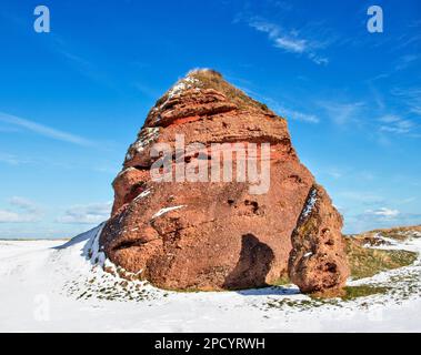 Cullen Bay Golfplatz Moray Scotland ein Meer aus altem roten Sandstein, umgeben von Schnee Stockfoto