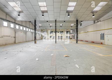 Leerer geräumiger Saal mit Metallbalken und Lampen, die für einen Parkplatz oder eine Fabrik vorbereitet sind. Konzeptlösung für den Mangel an Parkplätzen in der Stadt Stockfoto