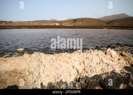 Altes, schmutziges Salz, das durch Regen und Wüstensand verdorben wurde, an der Seite der Verdampfungsbecken verworfen salinas de janubio Salzebenen Lanzarote, Kanarische Inseln, S. Stockfoto