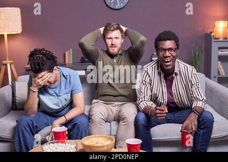 Vorderansicht einer Gruppe verwüsteter Sportfans, die sich ein Fußballspiel im Fernsehen ansehen Stockfoto