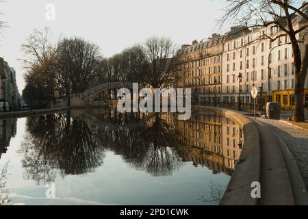 Die Gebäude Spiegeln Sich Im Stillen Wasser Des Canal Saint Martin, Paris Frankreich Am Frühen Morgen Im Frühling Wider Stockfoto