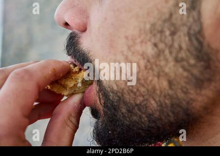 Der Mund beißt ein Stück Brot Stockfoto