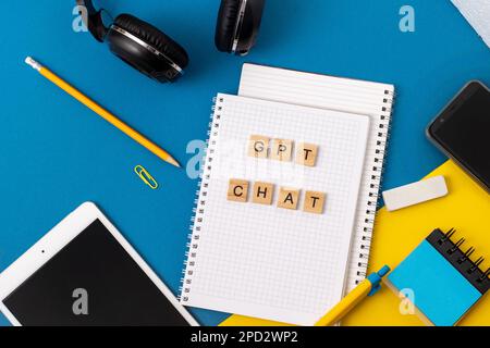 Arbeits- und Studienhintergrund mit Hilfe eines ChatGPT-bot. Wörter in Holzbuchstaben. Tischansicht mit freiem Notizbuchbereich. Chat-GPT zum Arbeiten und Erstellen. Ukraine, Kiew - 21. Februar 2023 Stockfoto