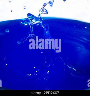 Abstraktes Wasser spritzt transparenter Meereshintergrund Gefrorener Tropfen über der flüssigen Oberfläche auf einem blauen Hintergrund für natürliche kosmetische Schönheit Sonnenschutz sp Stockfoto