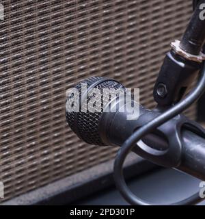 Instrumentalmikrofon vor dem Lautsprecher des Gitarrenkombinationsverstärkers Stockfoto