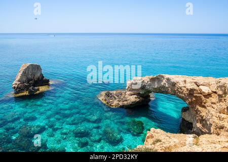 Ich liebe die Brücke in der Nähe von Ayia Napa auf Zypern. Natürliche Felsbogenformation, bekannt als Brücke der Liebenden am Kap Greco. Meereshöhlen an der Küste zwischen Agia Napa Stockfoto