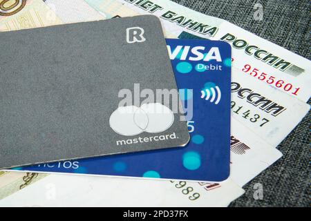 Visa und Revolut Mastercard liegen auf den russischen Rubel-Scheinen. Russischer Rubel. Russisches Geld. Unterschiedliche Stückelungen von Scheinen. Nahaufnahme. Stockfoto