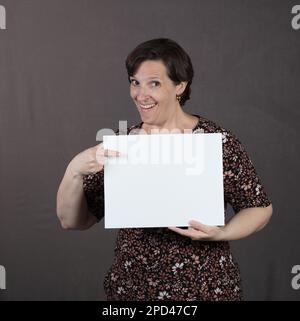 Eine Frau in einem Kleid mit einem weißen Schild Stockfoto