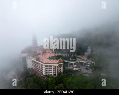 Genting, Pahang, Malaysia - 04 2022. Dez.: Ein mystischer und bezaubernder Blick auf den Tempel der Chin Swee Caves, umhüllt von einem nebligen Schleier an einem bewölkten Tag Stockfoto