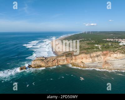 Leuchtturm in Nazare, Portugal. Berühmter Ort für Wellen und Surfen. Strand und Ozeanwellen im Hintergrund Stockfoto