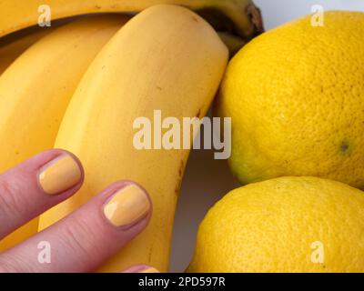 Nahaufnahme von Bananen- und Zitronenfrüchten auf weißem Hintergrund Stockfoto