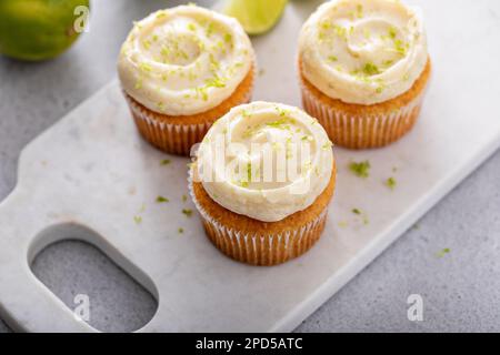 Kokosnuss- und Limetten-Cupcakes auf dem Servierbrett, Limettenkuchen-Dessert Stockfoto