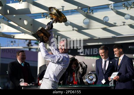 Jockey Nico de Boinville hebt die Trophäe, nachdem er am ersten Tag des Cheltenham Festivals auf der Cheltenham Racecourse die Trophäe „Unibet Champion Hürdle Challenge“ mit Constitution Hill gewonnen hat. Foto: Dienstag, 14. März 2023. Stockfoto