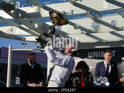 Jockey Nico de Boinville hebt die Trophäe, nachdem er am ersten Tag des Cheltenham Festivals auf der Cheltenham Racecourse die Trophäe „Unibet Champion Hürdle Challenge“ mit Constitution Hill gewonnen hat. Foto: Dienstag, 14. März 2023. Stockfoto