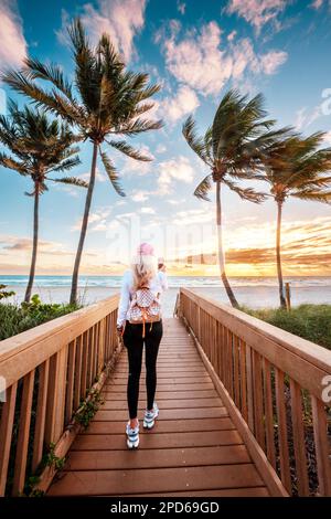 Frau genießt Sonnenaufgang, Spaziergang zum Strand, Fotos mit dem Telefon machen, Hollywood Beach, Hollywood, Miami Floridas Ostküste Miami Beach, Miami Flori Stockfoto