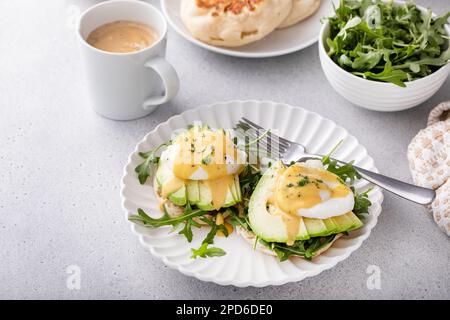 Gesundes Ei benedict Sandwich mit Avocado und Rucola, Frühstücksidee Stockfoto