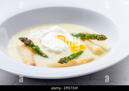 Weiße und grüne Spargelsuppe mit pochiertem Ei Stockfoto