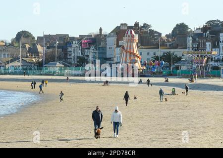 Weymouth, Dorset, Großbritannien. 14. März 2023 Wetter in Großbritannien. Spaziergänger am Strand genießen den warmen Frühlingssonnenschein am Nachmittag in Weymouth in Dorset. Bildnachweis: Graham Hunt/Alamy Live News Stockfoto