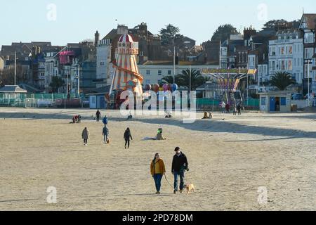 Weymouth, Dorset, Großbritannien. 14. März 2023 Wetter in Großbritannien. Spaziergänger am Strand genießen den warmen Frühlingssonnenschein am Nachmittag in Weymouth in Dorset. Bildnachweis: Graham Hunt/Alamy Live News Stockfoto