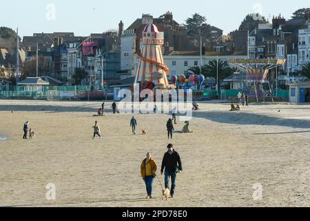 Weymouth, Dorset, Großbritannien. 14. März 2023 Wetter in Großbritannien. Spaziergänger am Strand genießen den warmen Frühlingssonnenschein am Nachmittag in Weymouth in Dorset. Bildnachweis: Graham Hunt/Alamy Live News Stockfoto