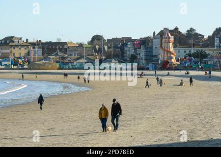 Weymouth, Dorset, Großbritannien. 14. März 2023 Wetter in Großbritannien. Spaziergänger am Strand genießen den warmen Frühlingssonnenschein am Nachmittag in Weymouth in Dorset. Bildnachweis: Graham Hunt/Alamy Live News Stockfoto