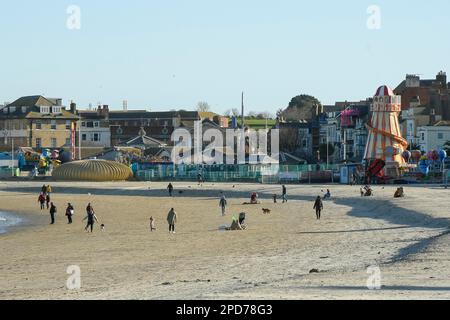 Weymouth, Dorset, Großbritannien. 14. März 2023 Wetter in Großbritannien. Spaziergänger am Strand genießen den warmen Frühlingssonnenschein am Nachmittag in Weymouth in Dorset. Bildnachweis: Graham Hunt/Alamy Live News Stockfoto