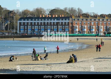 Weymouth, Dorset, Großbritannien. 14. März 2023 Wetter in Großbritannien. Spaziergänger am Strand genießen den warmen Frühlingssonnenschein am Nachmittag in Weymouth in Dorset. Bildnachweis: Graham Hunt/Alamy Live News Stockfoto