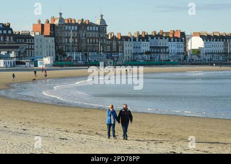 Weymouth, Dorset, Großbritannien. 14. März 2023 Wetter in Großbritannien. Spaziergänger am Strand genießen den warmen Frühlingssonnenschein am Nachmittag in Weymouth in Dorset. Bildnachweis: Graham Hunt/Alamy Live News Stockfoto