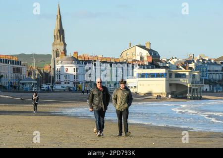 Weymouth, Dorset, Großbritannien. 14. März 2023 Wetter in Großbritannien. Spaziergänger am Strand genießen den warmen Frühlingssonnenschein am Nachmittag in Weymouth in Dorset. Bildnachweis: Graham Hunt/Alamy Live News Stockfoto