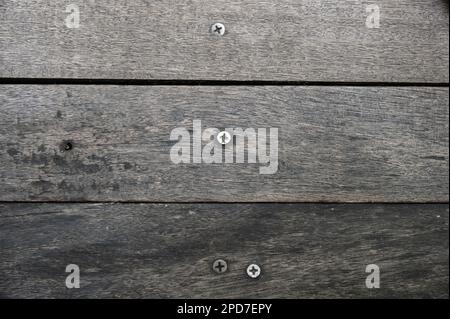 Konsistenz von altem Holz mit Schraube innen. Dunkelbraune Farbe. Stockfoto