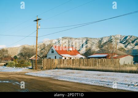 Haus mit rotem Dach und Bergen, Magdalena, New Mexico Stockfoto