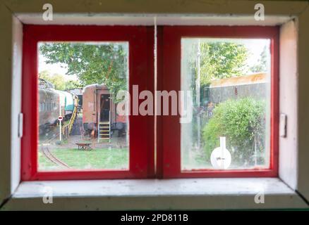 Altes Holzfenster mit Blick auf verlassene Züge Stockfoto