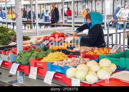 Ein Lebensmittelhändler, der Obst und Gemüse auf dem Riga Central Market in Riga, Lettland, verkauft Stockfoto