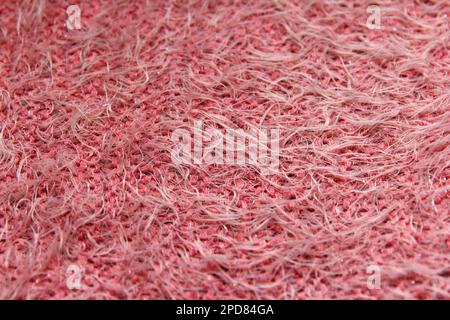 Die Oberfläche ist rosa gestrickt, warm, weich und flauschig. Der Hintergrund ist wunderschön, um Kleidung und Details des Innendesigns zu kreieren. Konzentriere dich auf die Mitte Stockfoto