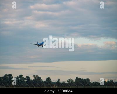 Blaues Passagierflugzeug im Himmel, Landung Stockfoto