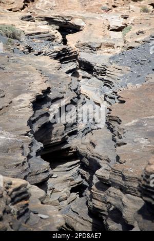 Vulkanische Felsschichten in Spalten, die von der Erosion der las grietas ladera del volcan Lanzarote, Kanarische Inseln, Spanien, abgenutzt wurden Stockfoto