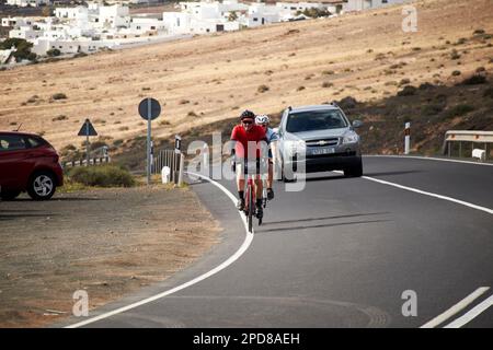 Zwei Radfahrer auf einer Bergstraße in Lanzarote, Kanarische Inseln, Spanien Stockfoto