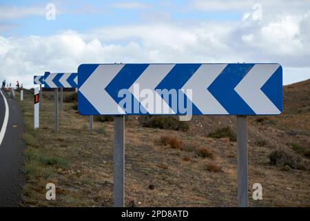 Warnschilder für gefährliche Straßenecken mit blauem und weißem Chevron: Lanzarote, Kanarische Inseln, Spanien Stockfoto
